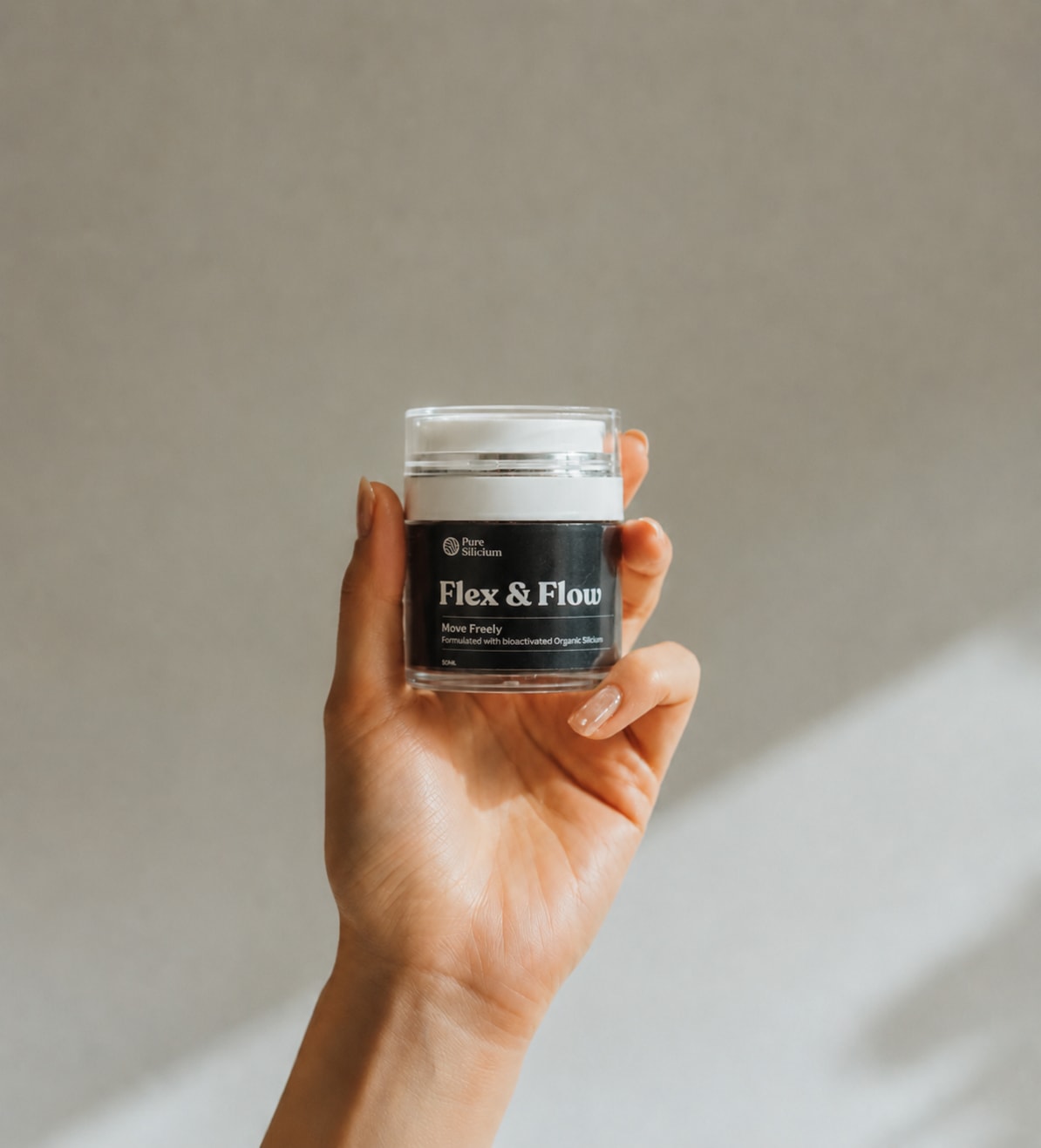 A hand holds a Flex & Flow jar in soft daylight